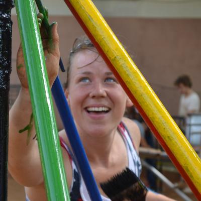 A construction volunteer in Ghana painting a playground structure. A Projects Abroad construction volunteer in Ghana painting a playground.